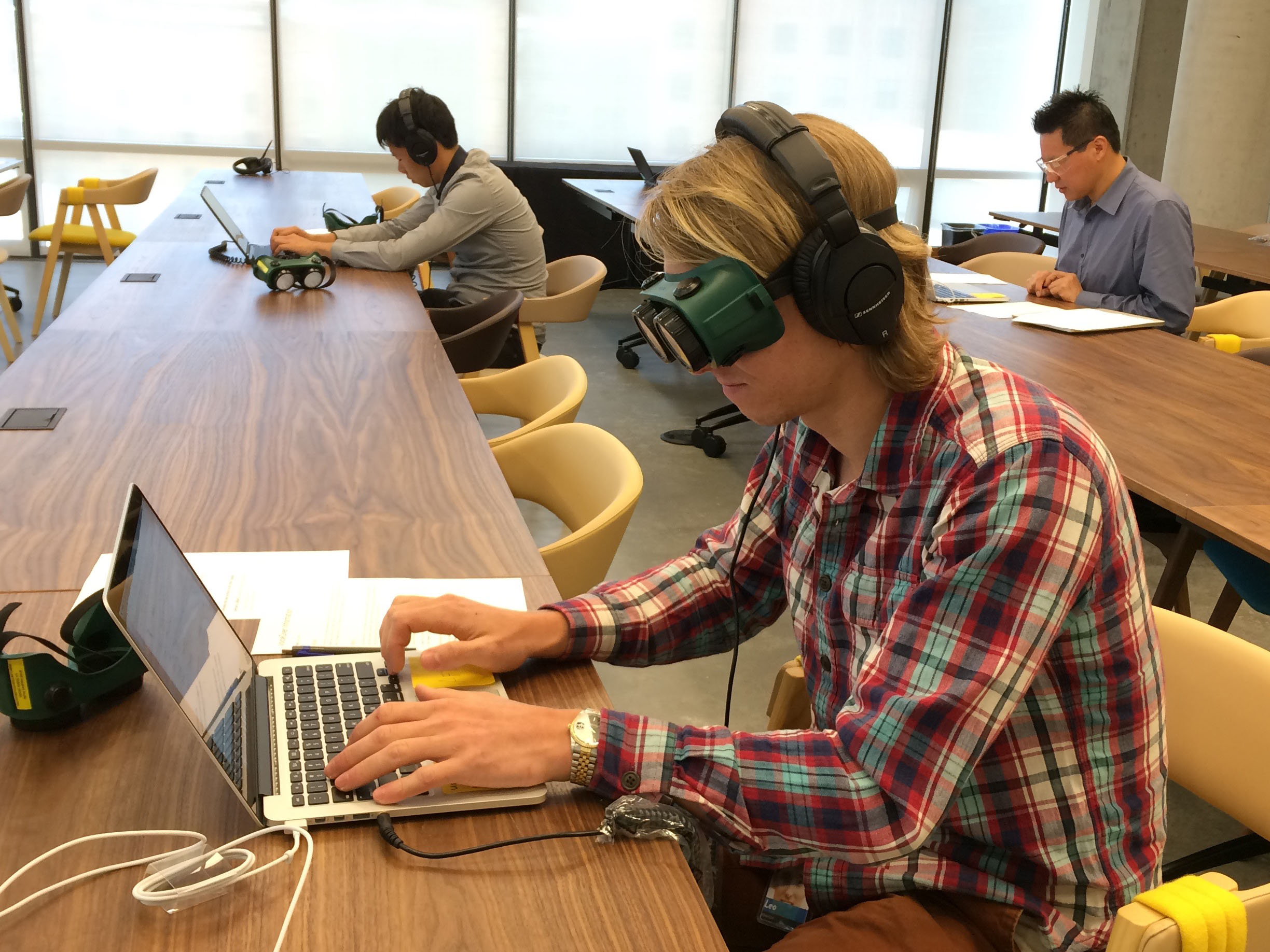 At another Assistive Technology Lab, someone wears headphones and special goggles that obscure their vision while they navigate dropbox.com with a screen reader.